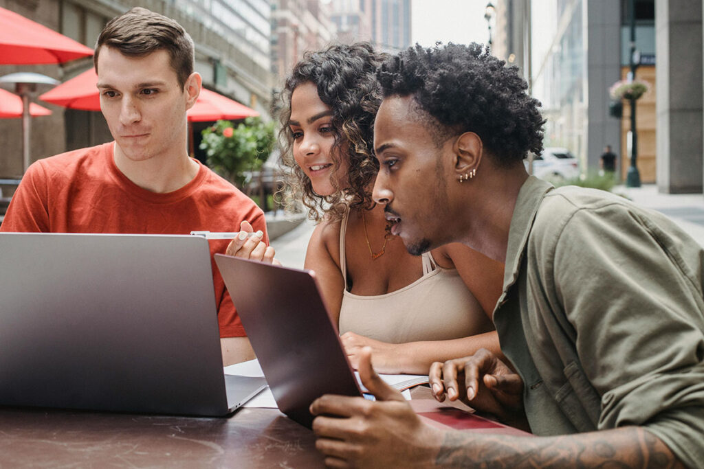 Una chica y dos chicos mirando la pantalla de un ordenador
