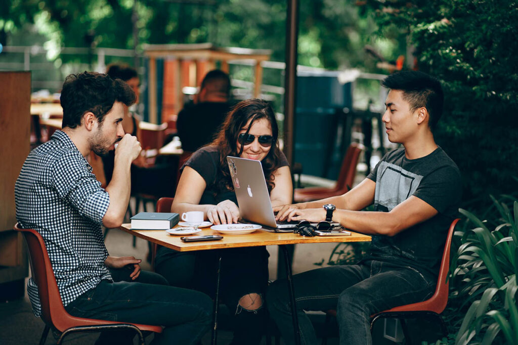 Tres personas teletrabajando juntas en un café