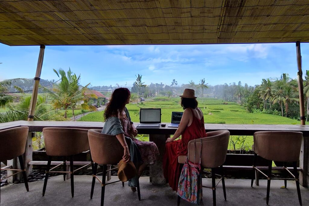 Dos mujeres con ordenadenadores con vistas a los arrozales