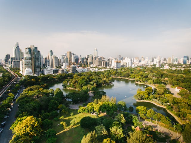 Vista aérea del parque Lumphini con el skyline de Bangkok al fondo.
