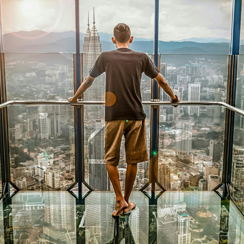 Hombre de pie observando las torres petronas des de lo alto